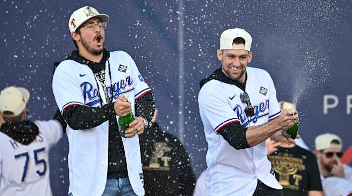 Rangers pitcher Dane Dunning, left and pitcher Nathan Eovaldi spray the crowd with champagne during the 2023 World Series champion celebration
